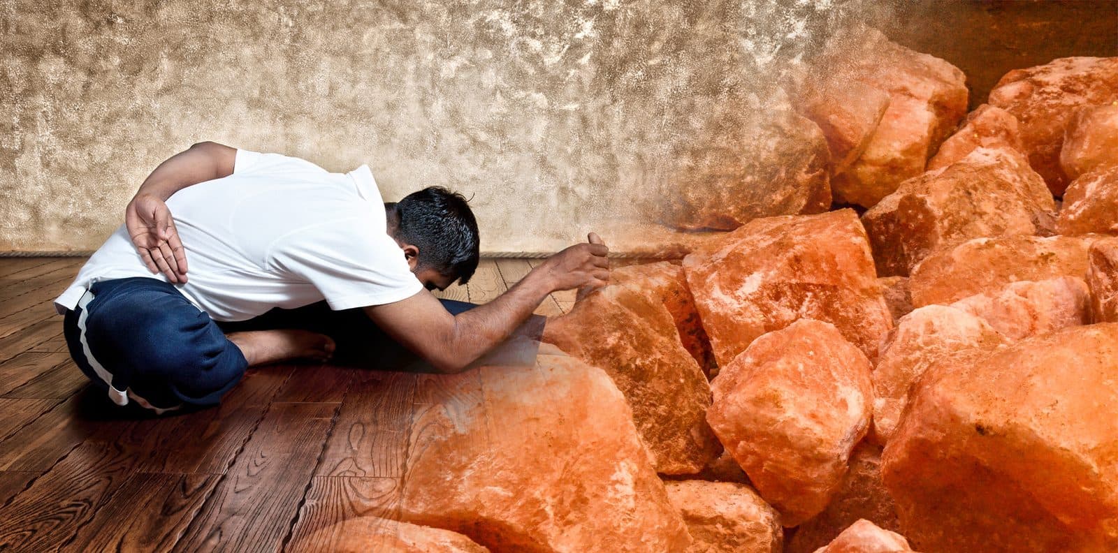 Una persona pratica yoga accanto a grandi blocchi di sale rosa